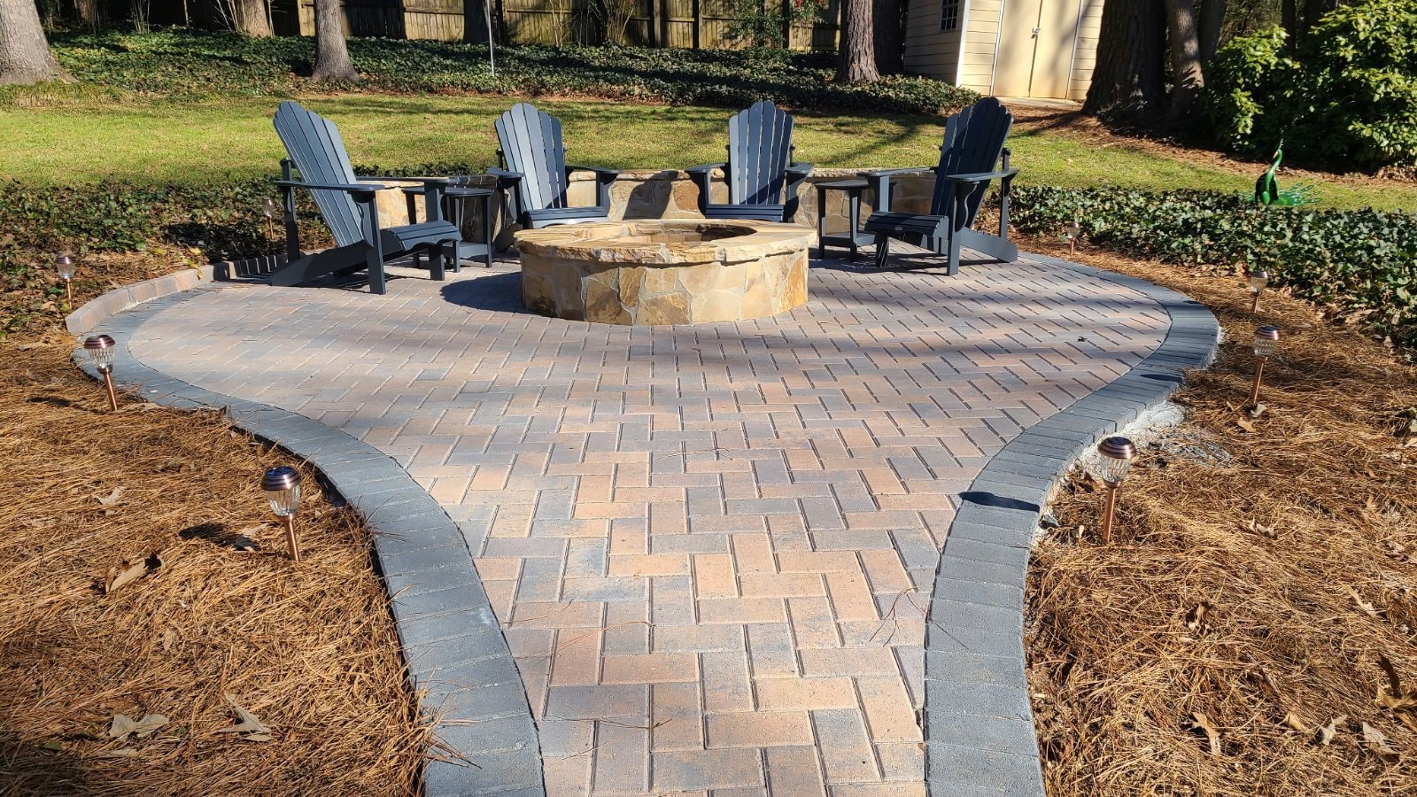 Holland herringbone paver patio with flagstone-veneered fire pit